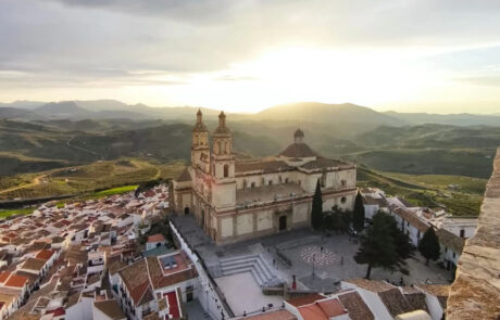 Plaza con escalinata de hormigón como elementos de equipamiento urbano frente la iglesia.