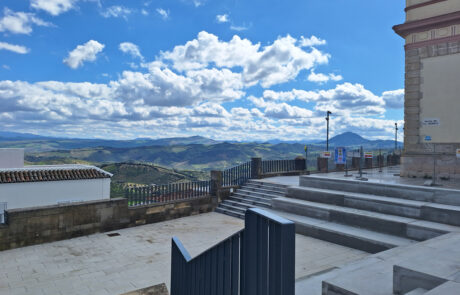 Escalinata de hormigón y barandilla metálica como elementos de equipamiento urbano con vistas al paisaje.