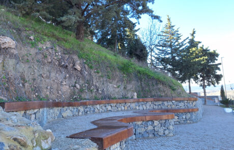 Bancos curvos de piedra y madera como mobiliario urbano.